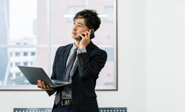 スーツ姿で電話している男性